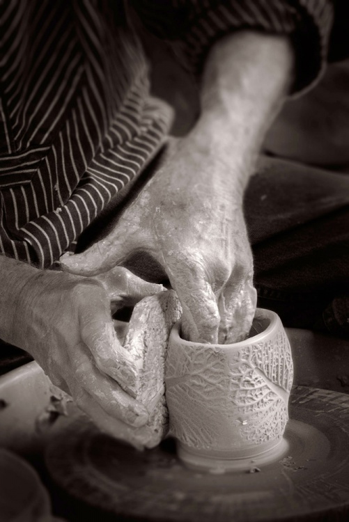Jack Troy texturing the side of a cup with a stamp