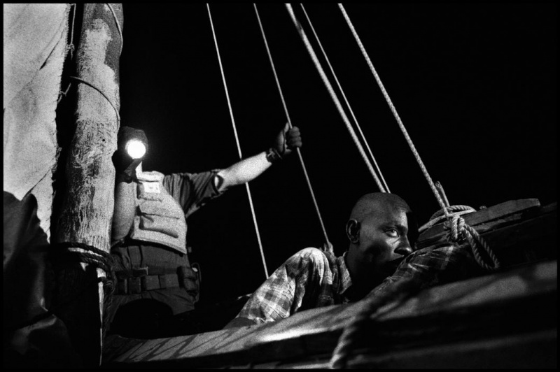 <p><b>Christopher Anderson</b>. HAITI. 2000. 44 Haitians attempt to sail from Haiti to the United States in a 23 foot homemade wooden boat named the Believe in God. As the boat sinks, the coast guard boards the boat to rescue its passengers. Here, a Haitiian man drifts in and out of consciousness from dehydration. He was too weak to stand and had to be carried from the boat.</p>