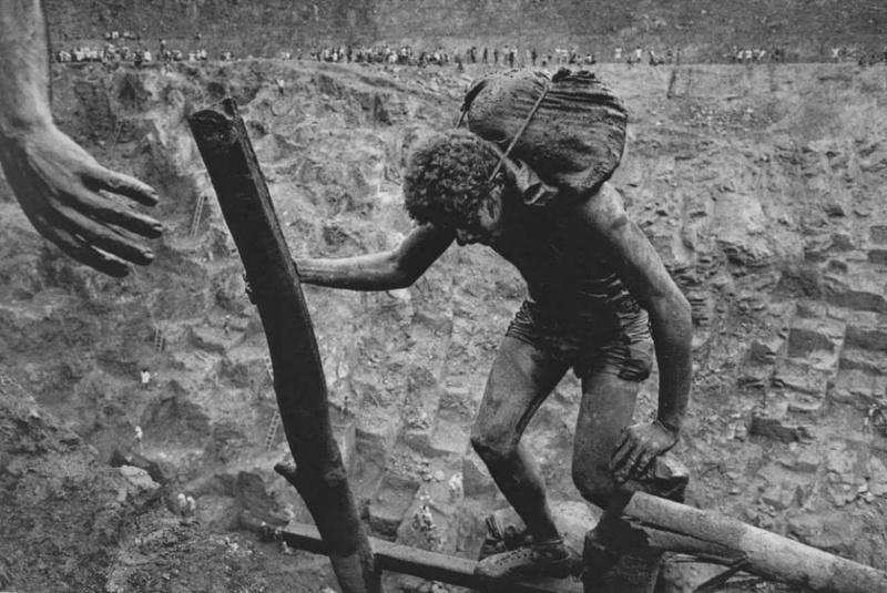 <p><b>Sebastião Salgado</b>, <i>GOLD, SERRA PELADA, BRAZIL: Carriers must keep their hands as free as possible to help balance on the dangerous ladders in the struggle from the mine bottom to the top. Serra Pelada, State of Pará, Brazil, 1986.</i></p>