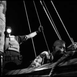<p><b>Christopher Anderson</b>. HAITI. 2000. 44 Haitians attempt to sail from Haiti to the United States in a 23 foot homemade wooden boat named the Believe in God. As the boat sinks, the coast guard boards the boat to rescue its passengers. Here, a Haitiian man drifts in and out of consciousness from dehydration. He was too weak to stand and had to be carried from the boat.</p>