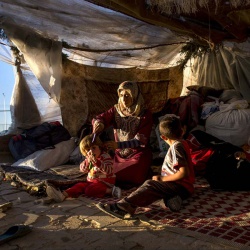 <p><b>Lynsey Addario</b>, 2013. Iman Zenglo, 30, sits with her five children in their tent she and her husband set up roughly three months prior in squalid conditions in a squatters camp outside of the Killis camp on the Turkish side of the Turkish Syrian border in Turkey, October 22, 2013.  Many Syrian refugees cross back and forth from Syria into bordering countries to work as laborers and visit family across borders....</p>