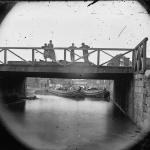 <p><b>Alexander Gardner</b>, <i>Richmond, Va. Bridge over the Canal; barges beyond</i>, 1865.</p>