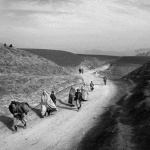 <p><b>Christopher Anderson</b>. AFGHANISTAN. Kunduz. 2001. People flee the fighting at the front lines of Kunduz. On the hills at top right and left are Northern Alliance troops manning the front lines.</p>