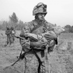 <p><b>James Natchwey</b>, <i>A Marine carries an Afghan child, one of two wounded by coalition aircraft during an air support mission</i>, 2011.</p>
