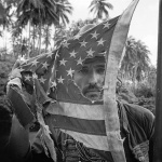 <p><b>Mary Ellen Mark</b>, <i>Dennis Hopper playing with an American flag, Apocalypse Now, Pagsanjan, Philippines, 1976.</i></p>