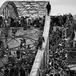 <p><b>Philip Jones Griffiths</b>, <i>VIETNAM. Hue. Refugees flee across a damaged bridge. Marines intended to carry their counterattack from the southern side, right into the citadel of the city. Despite many guards, the Vietcong were able to swim underwater and blow up the bridge, using skin-diving equipment from the Marines.</i></p>