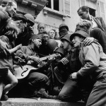 <p><b>Robert Capa</b>, <i>FRANCE. Cherbourg. June 28, 1944. American soldiers and French civilians celebrating the liberation of the city in front of Cherbourg's city hall.</i></p>