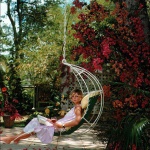 <p><b>Slim Aarons</b>, <i>Barbados Bliss</i>, 1976. Ava Marshall relaxes with a book amongst the bougainvillea in Barbados, April 1976. © Slim Aarons</p>