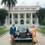 <p><b>Slim Aarons</b>, <i>Donald Lease</i>, 1968. April 1968: Mr and Mrs Donald Lease with their Rolls Royce and two pet dogs outside their home in Palm Beach, Florida. © Slim Aarons</p>