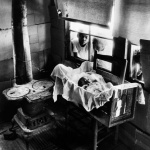 <p><b>W. Eugene Smith</b>, <i>Newborn baby in makeshift crib near cold stove. South Carolina, USA. 1951.</p>